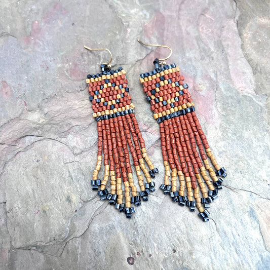 Beaded earrings on a stone surface