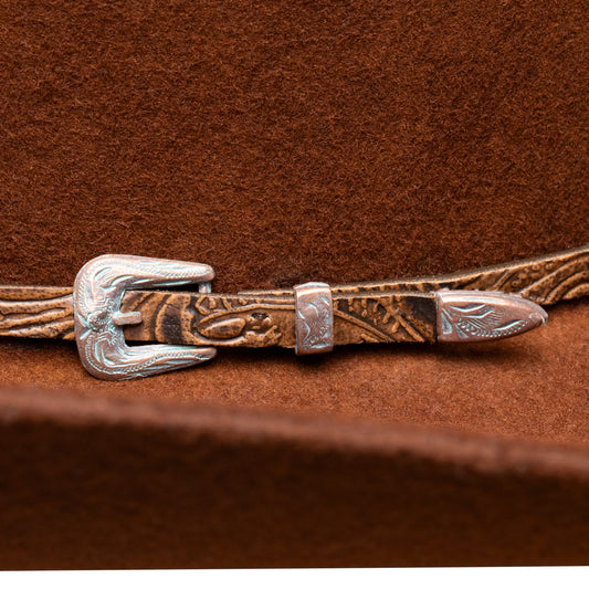 Close-up of a brown leather belt with a silver buckle on a matching brown background